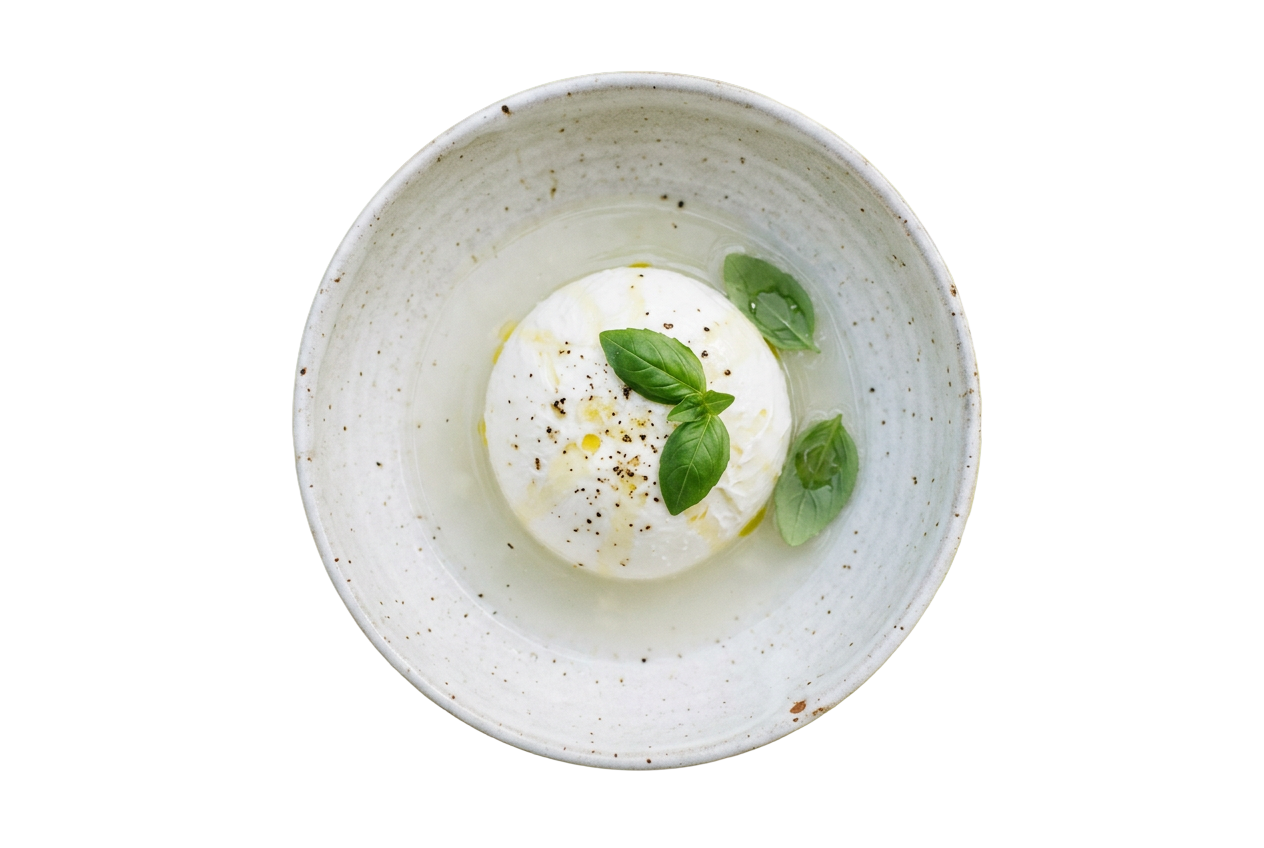 Queijo burrata fresco com folhas de manjericão e fio de azeite numa taça de cerâmica, especialidade do Grupo Casa Nova.