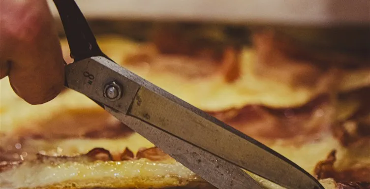 Corte tradicional italiano de fatia de pizza retangular com tesoura própria na Pizza a Pezzi.