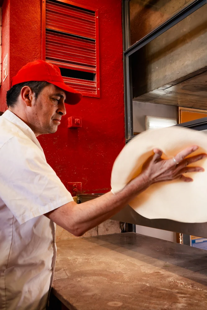 Pizzaiolo preparando uma massa de Pizza na Pizzaria Casa Nova