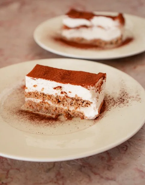 Fatia de tiramisù tradicional italiano polvilhada com cacau em pó, sobremesa clássica do restaurante Casanova.